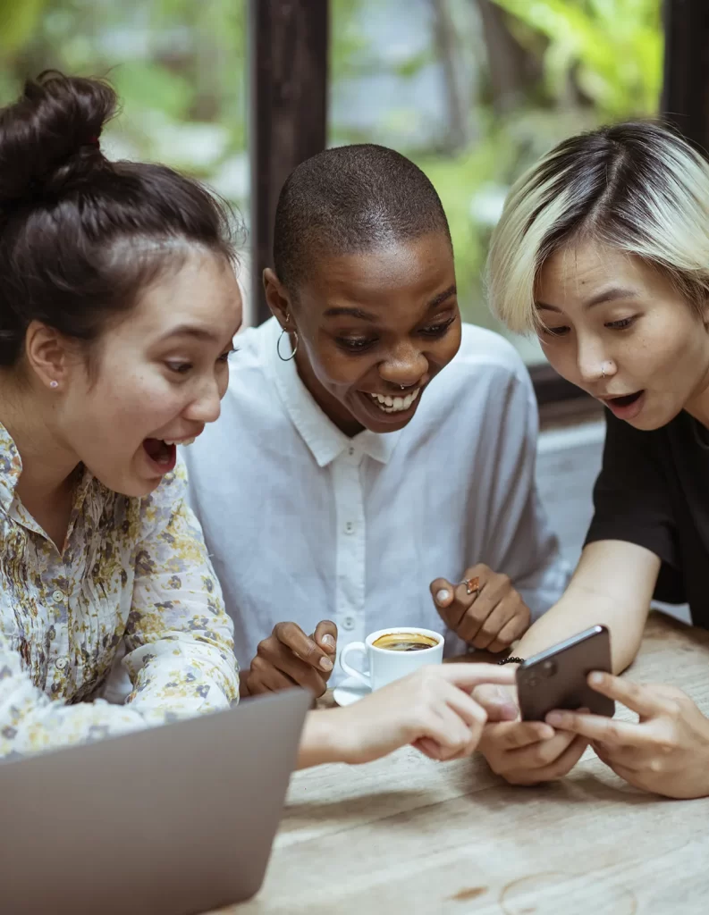 Tres personas viendo algo divertido en un smartphone
